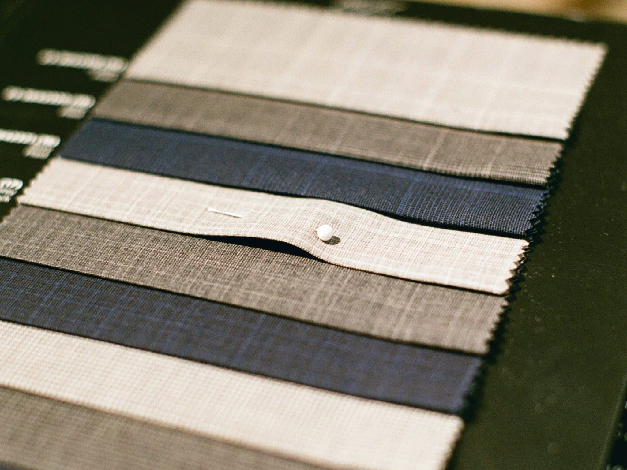 Fabric swatch card in navy, grey and stone suiting cloths